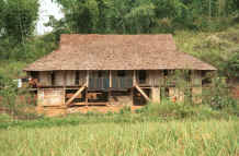 to Jpeg 42K Black Thai house with six mattresses hanging out air.  Note the coverings in indigo cloth and edges with hand woven supplementary weft cloth on the road north leaving Son La, Son La Province. 9510C27.JPG