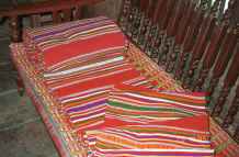 to Jpeg 47K A roll of weaving for cutting into bag lengths and cushion and mattress ends, Black Thai village, Dien Bien Phu, Lai Chau Provine.  Note the cushion edge using similar weaving just showing which has been covered by a protective raffia mat. 9510D02.JPG