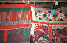 to Jpeg 40K Curtains separating sleeping from living areas in a Black Thai house.  Note the woven fabric in the heading to the left and patchwork in the heading to the right.  The hanging tabs echo those on some of the baby carriers.  Dien Bien Phu, Lai Chau Province. 9510D15.JPG