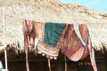 to Jpeg 38K Black Thai baby carrier hanging on a line outside a house in a village near Dien Bien Phu, Lai Chau Province. 9510E02.JPG