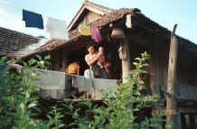 to Jpeg 32K Black Thai family coming out to say good bye - the baby is shown in the baby carrier in the Photo gallery to the left above this thumbnail and the woman's blouse shown further above was in the process of being sewn when we came along.  Dien Bien Phu, Lai Chau Province. 9510E28.JPG