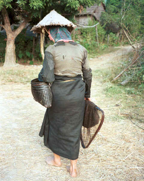 Jpeg 41K Black Thai young woman cycling out of her village wearing a straw hat over her head dress to give added protection from the sun.  Dien Bien Phu, Lai Chau Province. 9510E29.JPG