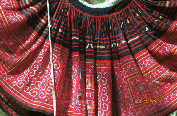 Detail of Red Hmong (Lai Chau province, northern Vietnam) woman's skirt showing the waist gathering, applied strips of red fabric and small triangles to the top border and cross-stitch with applied floral rectangles in the bottom border 9510f27.jpg