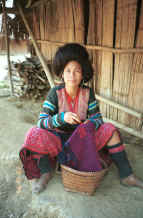 to Jpeg 44KRed Hmong woman working (from the back) on the cross-stitch border of the bottom band of a new skirt similar to the one which she is wearing 9510f31.jpg