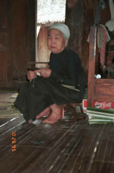 Jpeg K This poor quality photo is interesting in that it shows an elderly Southern White Thai, (Tai Mai Chau), woman wearing the traditional everyday white headcloth left un-dyed which is now infrequently worn.  She is wearing a skirt with a black (or indigo) body and without a hem piece.  With this she is wearing a black blouse with slim arms in the older fashion rather than a modern style blouse from commercial cloth.  Mai Chau District in Hoa Binh Province but near the border with the north-western part of Thanh Hoa Province in north west Vietnam. 9510A09.JPG