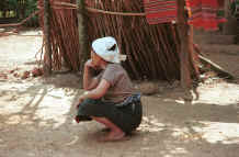 to Jpeg 36K Southern White Thai, (Tai Mai Chau), woman wearing the traditional everyday white headcloth left un-dyed which is now infrequently worn.  She is wearing a skirt with a black (or indigo) body and without a hem piece.  Mai Chau District in Hoa Binh Province near the border with the north-western part of Thanh Hoa Province in north west Vietnam. 9510A21.JPG